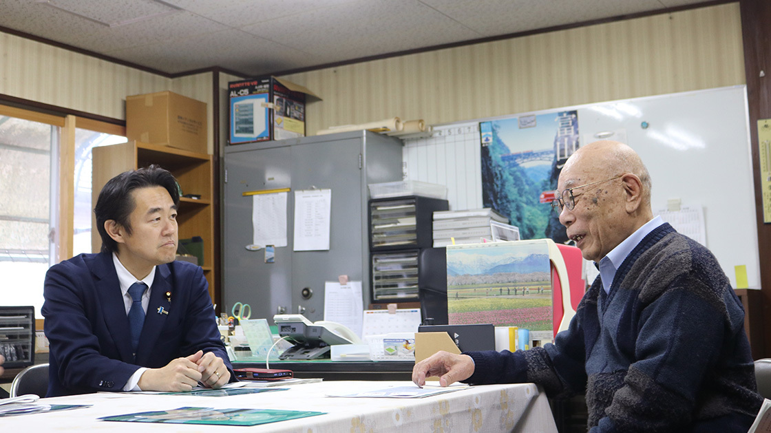 An image of Mr. Hosaka, State Minister for Digital Transformation, sitting and exchanging opinions with Oumi CEO at the Kuroto Jidosha Shokai office