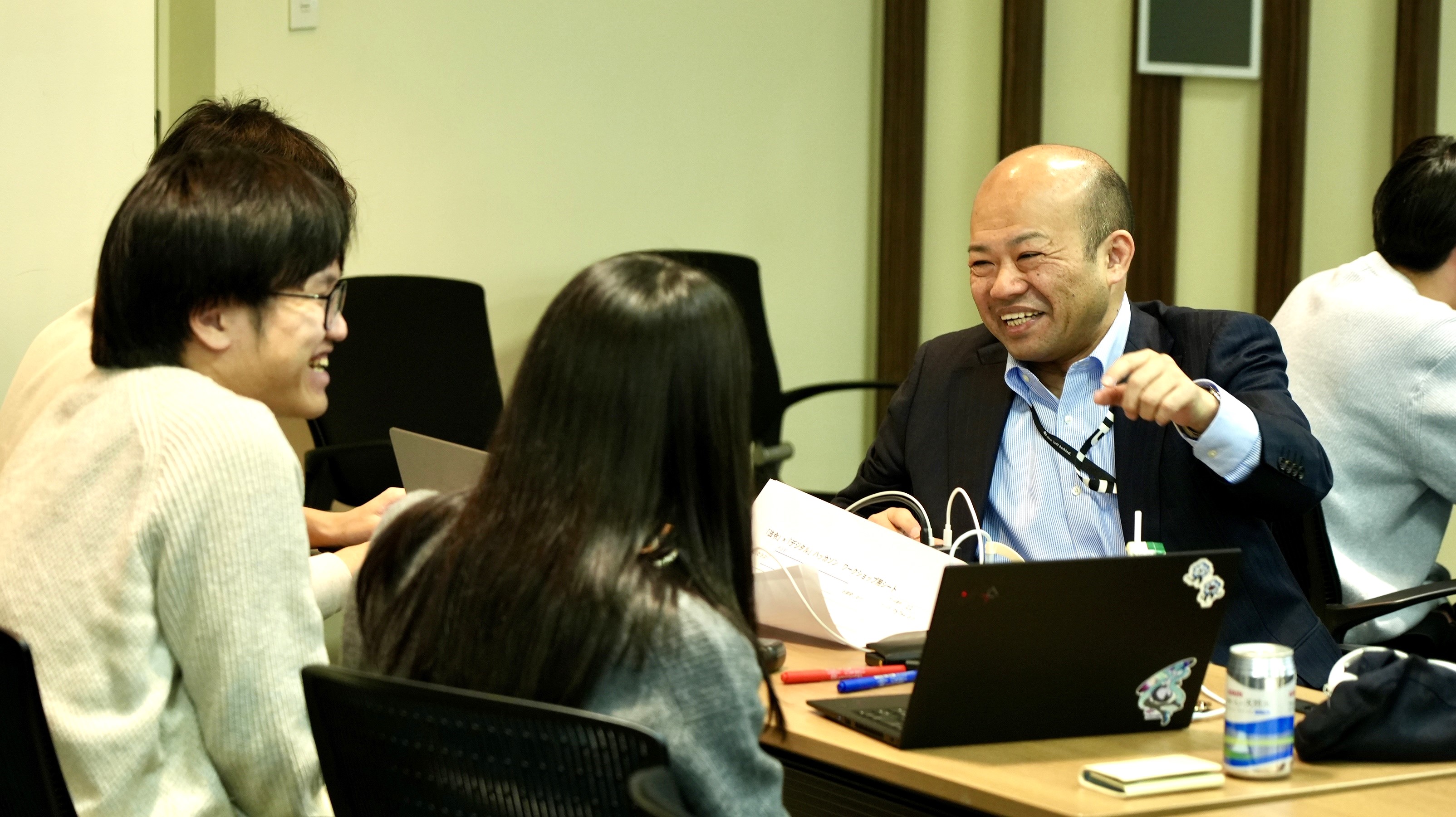 Director Kawano in Digital Agency goes to the tables of the participants of the hackathon and supports them in coming up with ideas for the works to be developed. 