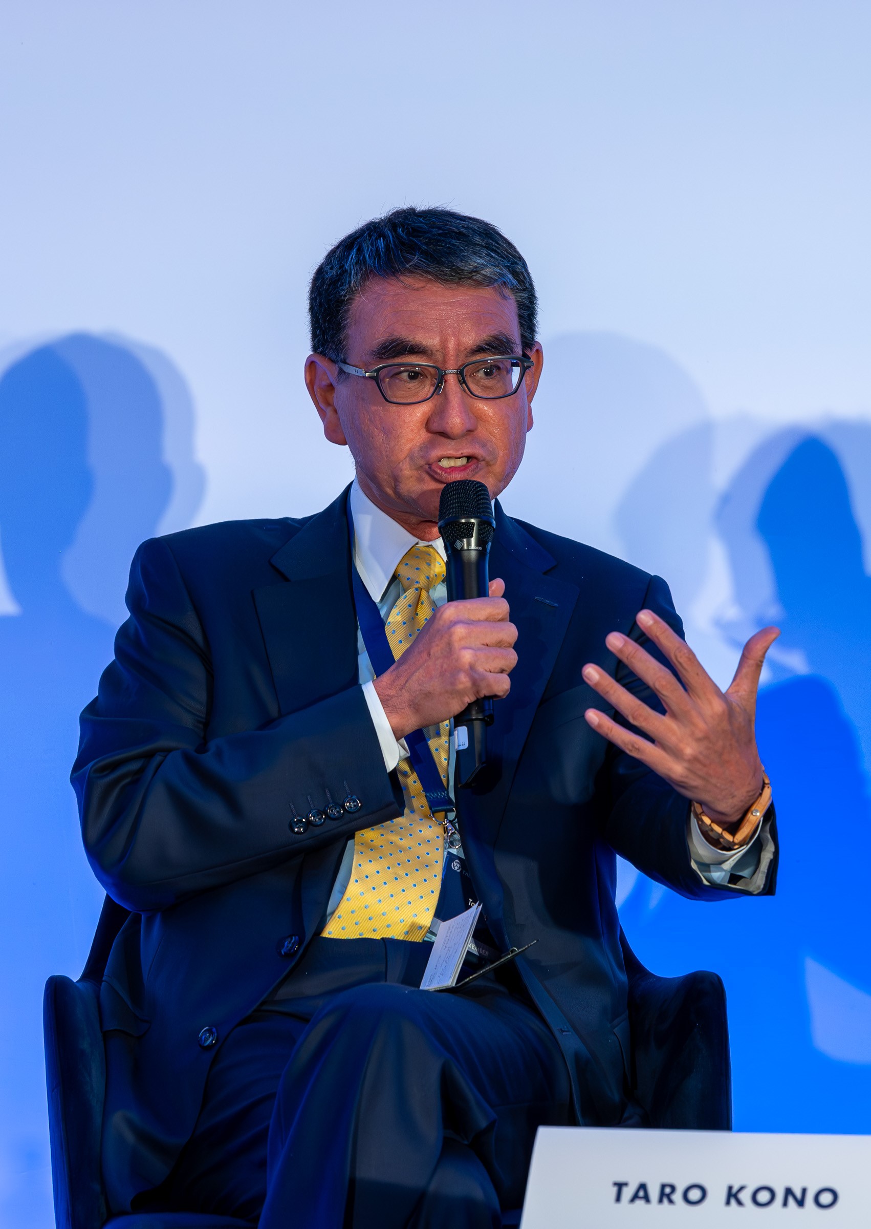 A photo of Mr. Kono, Minister for Digital Transformation, having a conversation with a microphone.